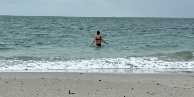 Tash standing waist-deep in the ocean on her 44th birthday, reflecting on self-worth and personal growth